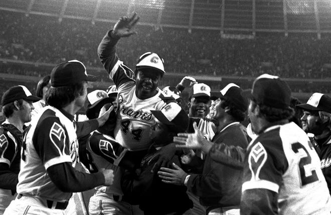 Henry Aaron is surrounded by teammates and fans after hitting his 715th career home run at Fulton County Stadium in Atlanta on April 8, 1974. How Atlanta lured the Braves from Milwaukee, and teams in the other three major-league sports in the 1960s, is the focus of "Loserville."