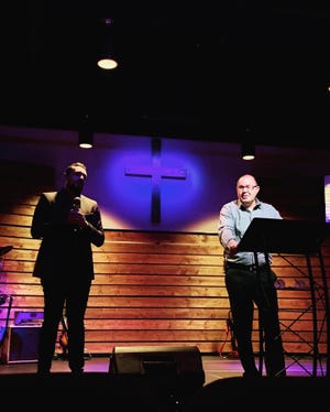 Hope Baptist Pastor Will McReynolds, right, during the church's Bilingual Candlelight Christmas Eve service at its new location in Lebanon Outlet Marketplace. Interpreter Mishael Rocha is on the left.