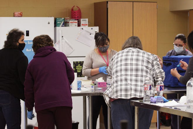 Cuatro enfermeras de la Escuela Independiente de Gadsden y dos empleados del Ministerio de Salud preparan las vacunas COVID-19 en la Escuela Secundaria de Gadsden el viernes 22 de enero de 2021.