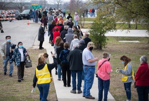 Hundreds of people who made an appointment to be vaccinated against COVID-19 stand in a line that wraps around a building at the Delco Activity Center in northeast Austin, Texas, on Jan. 23.