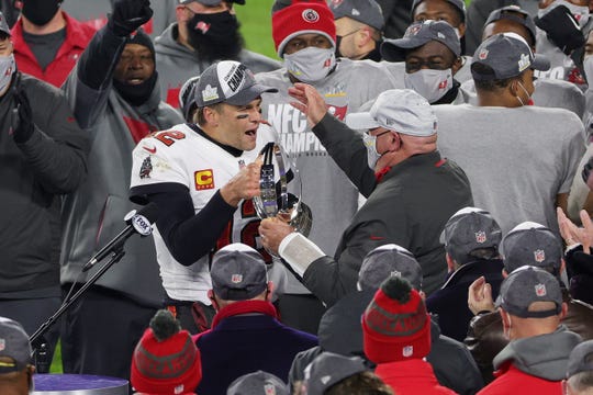 Tom Brady celebrates with coach Bruce Arians and teammates after The Bucs beat Green Bay to reach the Super Bowl.