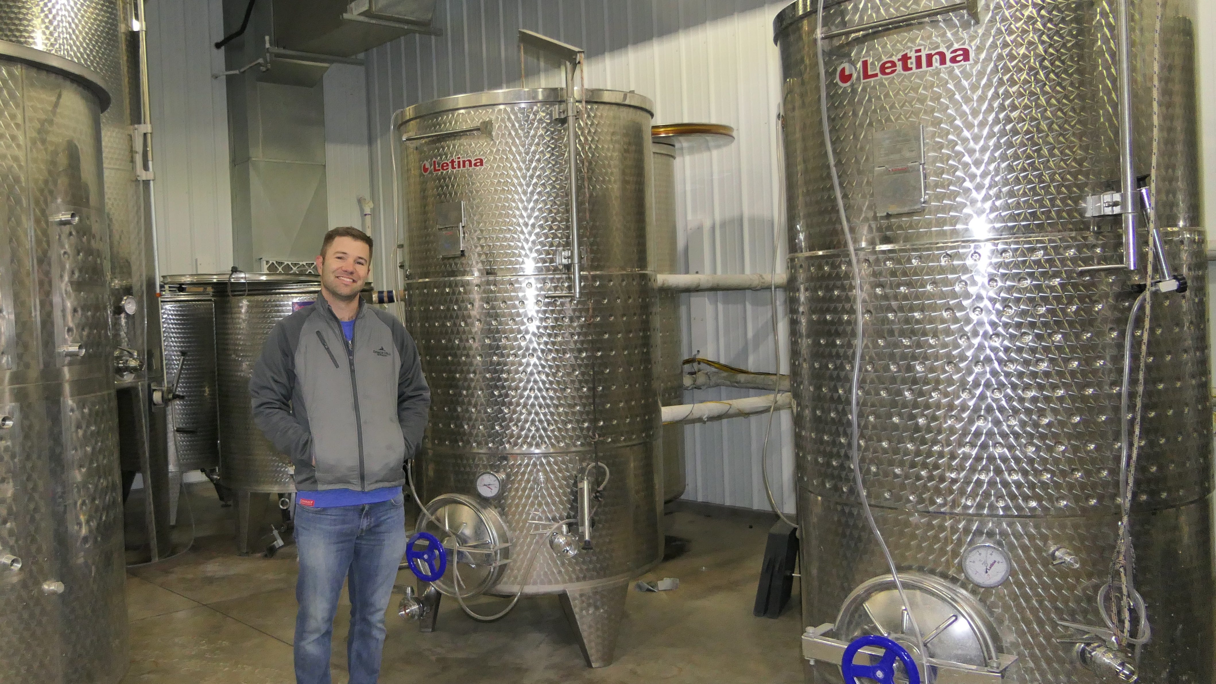 Jeff Solo, the manager at Grace Hill Winery, stands in front of wine tanks at the winery in Whitewater.