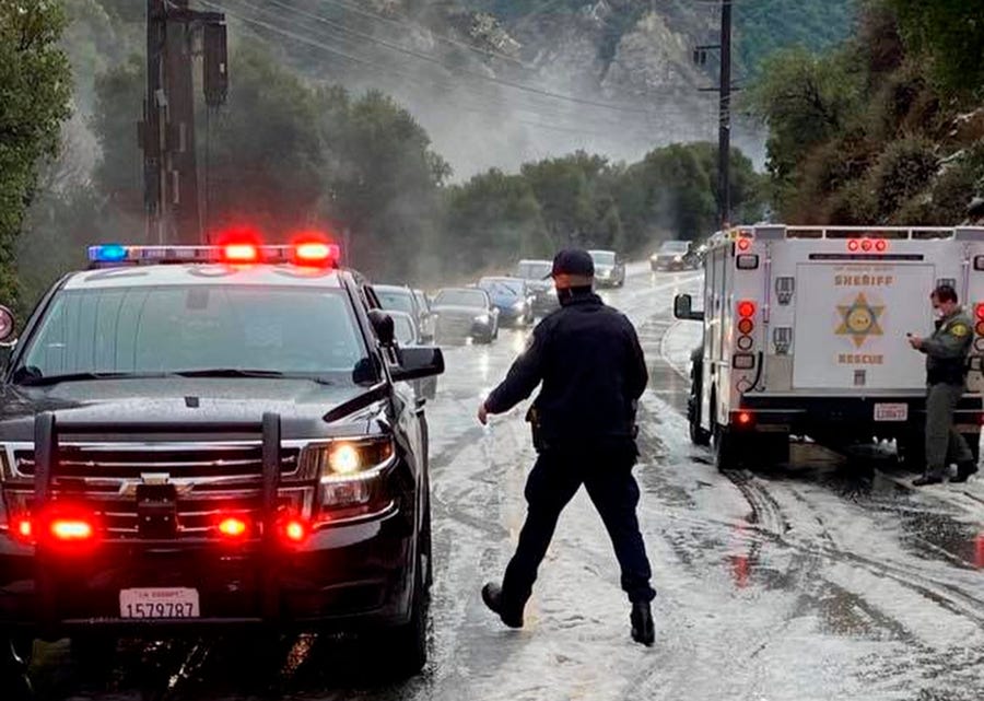 In this Saturday, Jan. 23, 2021, photo provided by the California Highway Patrol-West Valley, authorities work the scene of an accident after a hail storm on Malibu Canyon Road in Malibu, Calif.