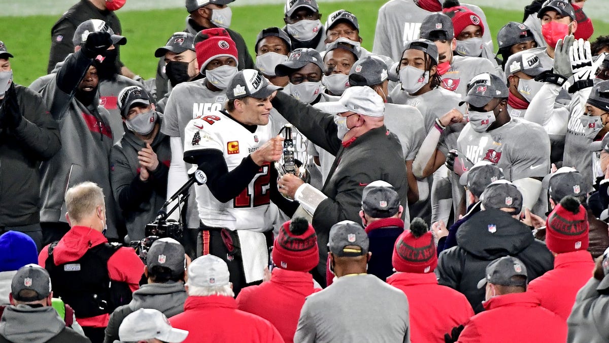 Tampa Bay Buccaneers quarterback Tom Brady and head coach Bruce Arians celebrate with the George Halas Trophy.