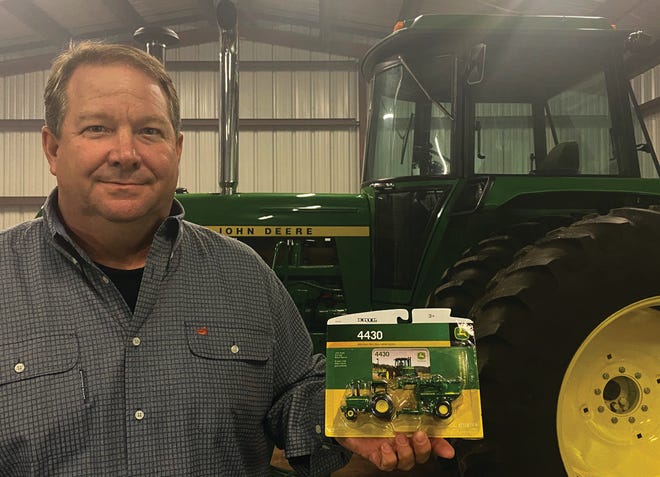 Rob Marrionneaux displays the tiny version of his newly acquired 1977 John Deere 4430 tractor, which looms in the background at his home in Grosse Tete. Marionneaux purchased the mint-condition vintage tractor through an auction.