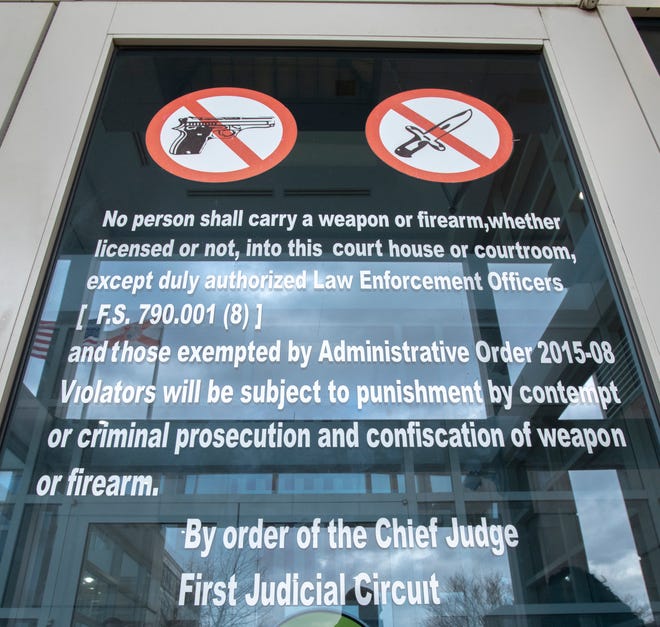 A "no weapons or firearms" sign is displayed at the entrance of the Escambia County M.C. Blanchard Judicial Building in downtown Pensacola on Tuesday, Jan. 26, 2021.