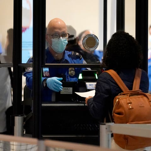 In this Nov. 24, 2020 file photo, a TSA agent assi
