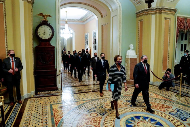 Huissecretaris Cheryl Johnson, Rep. Jamie Raskin (D-Maryland) en Rep. David Cicilline (R-Rhode Island) lopen door de State Room van het Capitool om de afzettingsartikelen tegen voormalig president Donald Trump in januari 2021 af te leveren.