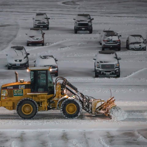 Crews clear snow from a parking lot at O'Hare Inte