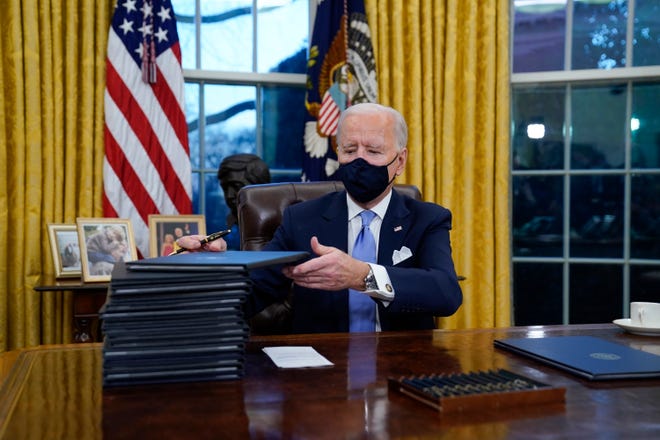 President Joe Biden signs his first executive orders in the Oval Office of the White House in Washington. Six of Biden's 17 first-day executive orders dealt with immigration, such as halting work on a border wall in Mexico and lifting a travel ban on people from several predominantly Muslim countries. 