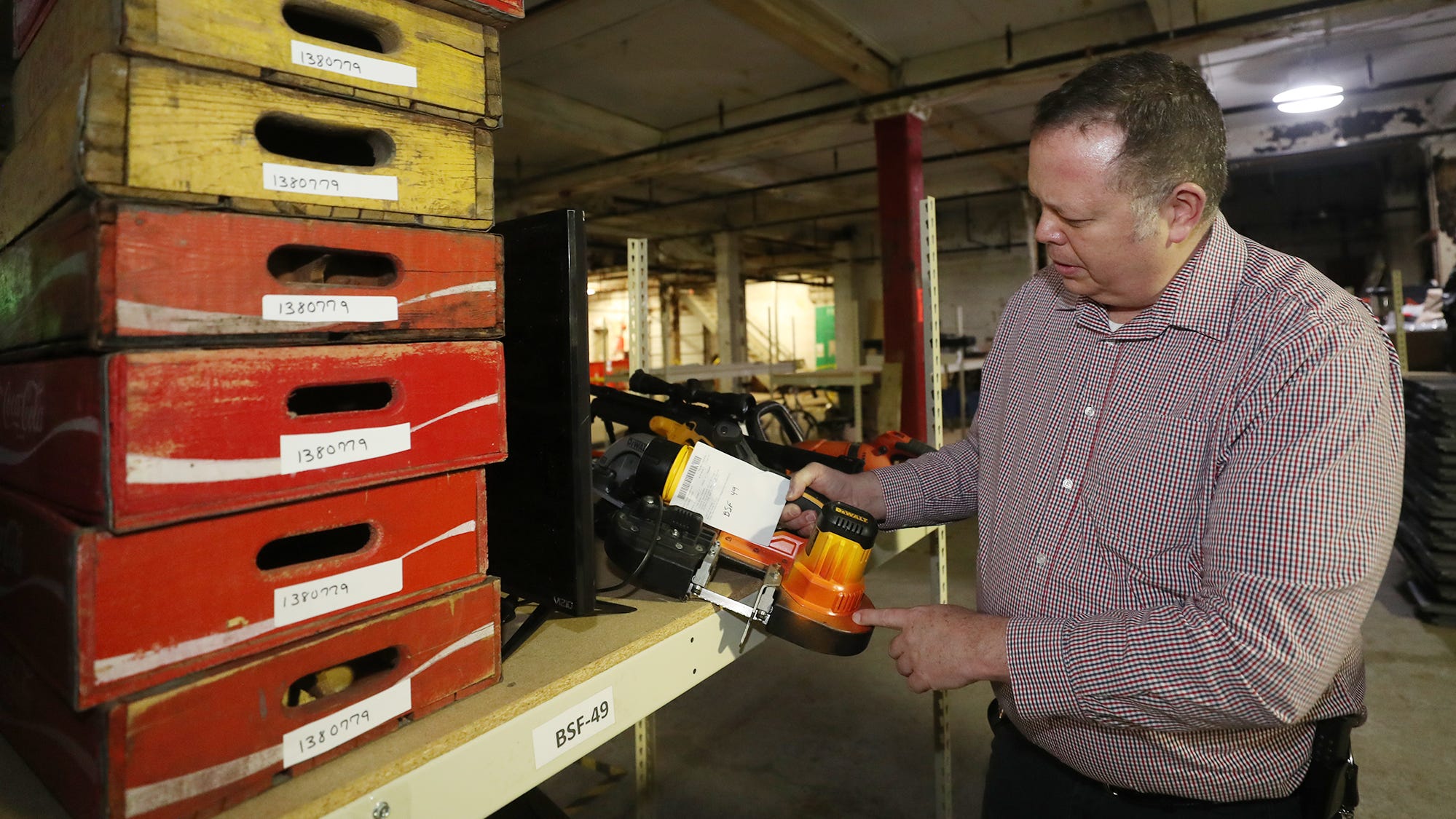 Akron police Detective Brian Hamilton talks about a power tool that was painted orange to identify it.