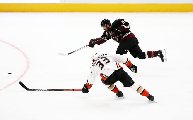 Jan 26, 2021; Glendale, Arizona, USA; Arizona Coyotes right wing Conor Garland (83) takes a shot against Anaheim Ducks right wing Jakob Silfverberg (33) in the second period at Gila River Arena. Mandatory Credit: Rob Schumacher-Arizona Republic