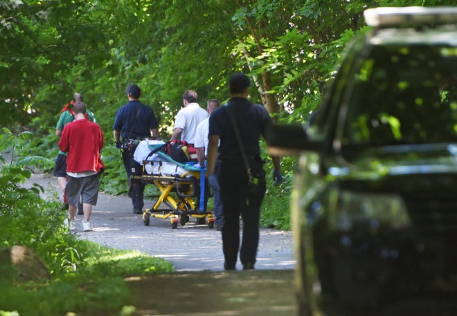 Police, firefighters, an overdose victim who was revived and his friend walk toward the ambulance for the victim to be checked out while on the Dover Community Trail.  His friend called 911 and no arrests were made due to the 911 Good Samaritan Law.