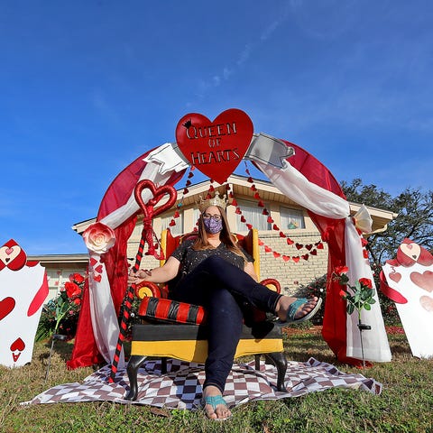 Meghan Davis sits in her Alice in Wonderland displ