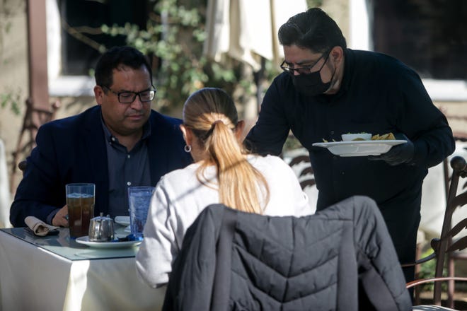Hector Hinojosa serves diners at The Cafe at Shields in Indio, Calif. on Thursday, January 28, 2021. Restaurants in Southern California were permitted to reopen outdoor dining after Gov. Gavin Newsom ended the COVID-19 stay-at-home order on Monday.