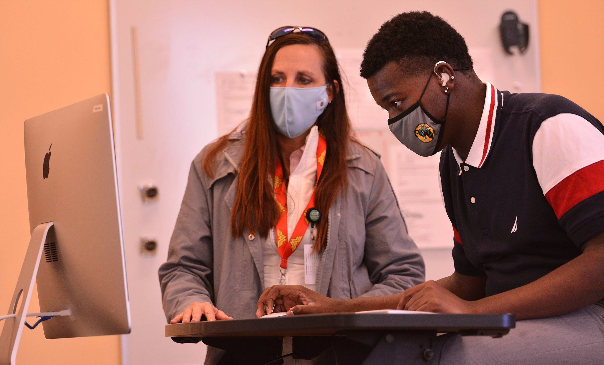 Students in Iosep MacDougall's Digital Arts class work on a project at the South Carolina School for the Deaf and the Blind, in Spartanburg, Thursday, January 28, 2021. Cherie Winkler, principal of the Applied Academic Center, helps Tyrelle Stevenson, right, during the class.