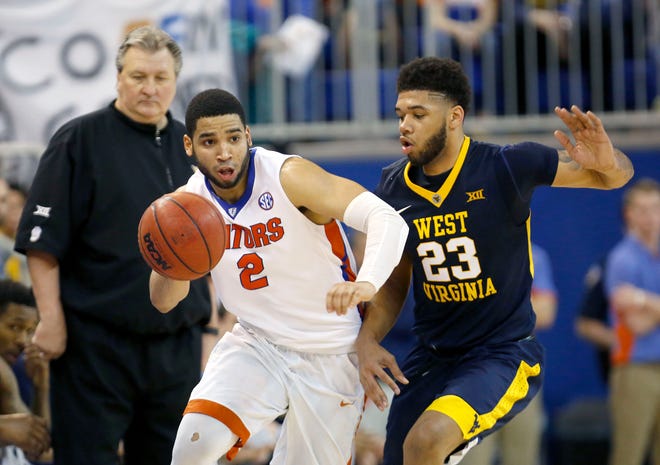 Florida guard Brandone Francis-Ramirez dribbles up the court past West Virginia forward Esa Ahmad (23) and head coach Bob Huggins during the second half of the Jan. 30, 2016 game at the O'Connell Center. Florida defeated West Virginia 88-71.