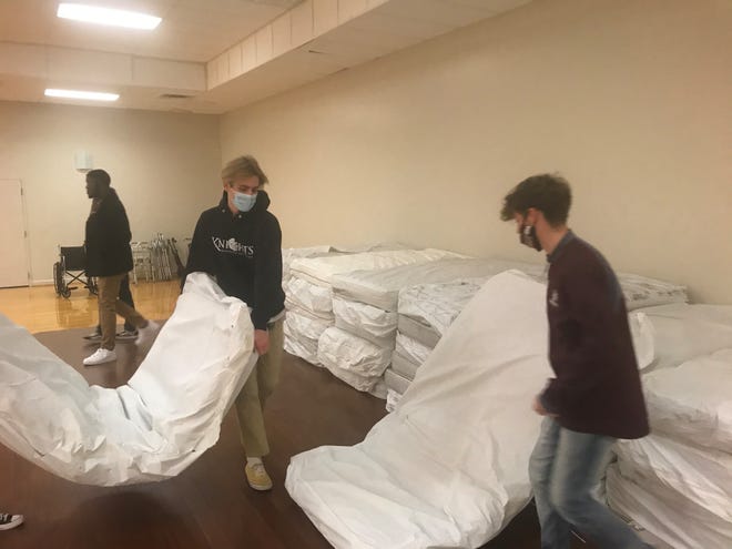 Sacred Heart of Jesus High School students stack mattresses and cots that were donated for a Leadership Jackson project at The Star Center. The entire job took about three hours to unload all of the bedding.