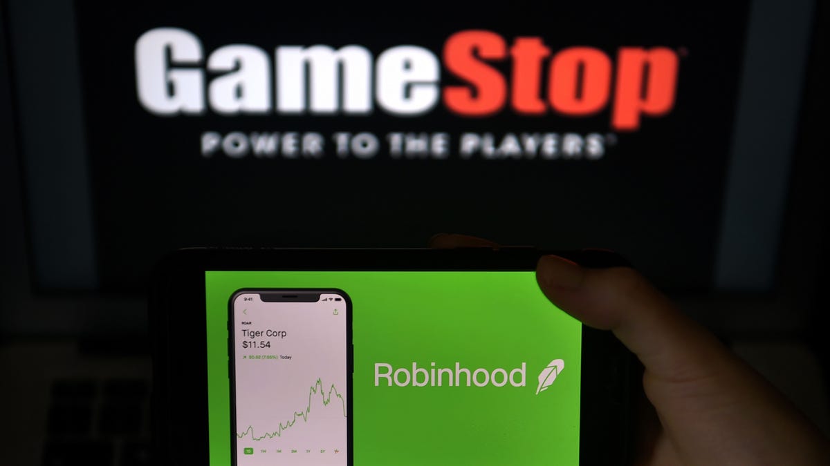 This photo illustration shows the logos of video game retail store GameStop and trading application Robinhood in a computer and on a mobile phone in Arlington, Virginia on January 28, 2021.