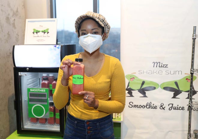 Taylor McKinnie, owner of Mizz Shakesum Smoothie u0026 Juice Bar, holds one of her smoothies at the Northside Marketplace in Akron.