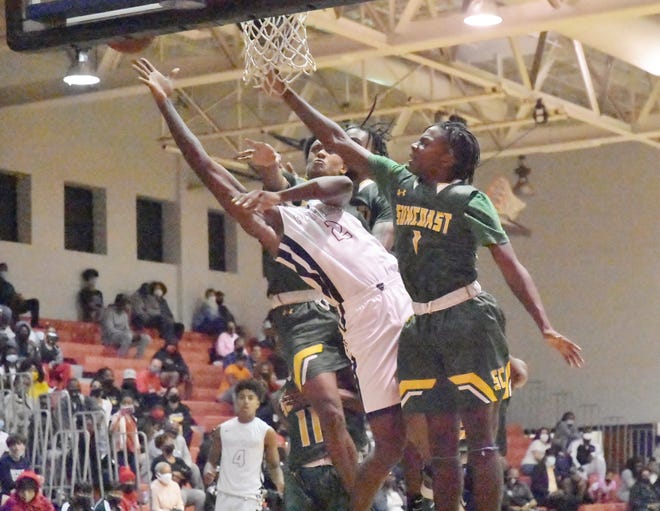 Dwyer senior Rodrick Johnson Jr. drives to the basket and makes a difficult layup for two of his team-high 17 points as Suncoast defenders crash into him during Friday nights game.