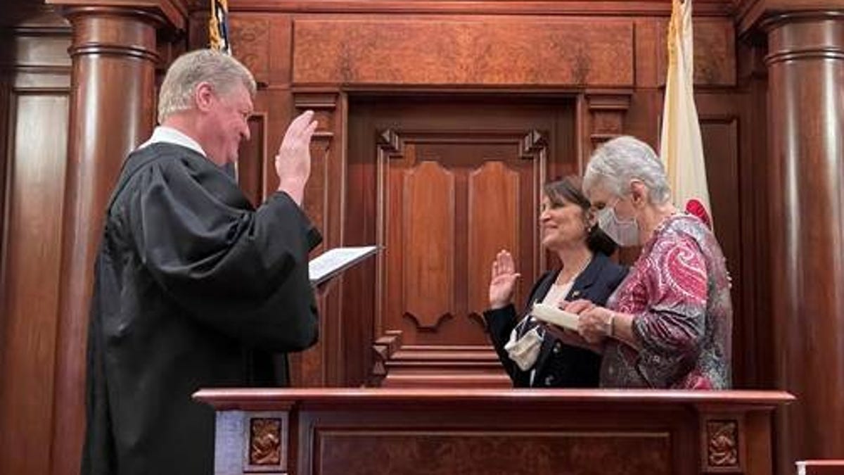 Sally Turner, center, is sworn into the Illinois Senate on Saturday by her husband, Appellate Judge John Turner. At right is the senator's mother.