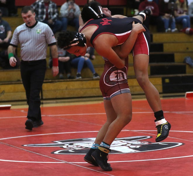 Dover's Pedro Garcia has New Philadelphia's Ezekiel Williams in a fireman's carry in the 138-pound match Saturday afternoon.