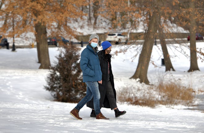 A couple walks through Elm Park in January.