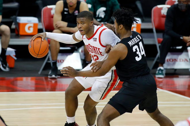 Ohio State star power forward E.J. Liddell is defended by Julius Marble in the first half of the Buckeyes' win over the Spartans on Jan. 31 in Columbus.