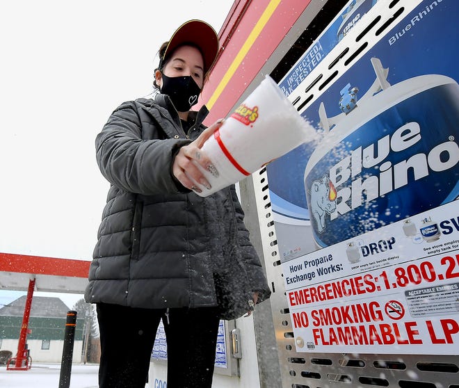 Rutter's employee Katie Smith spreads salt outside the New Freedom convenience store after snow began falling Sunday, Jan. 31, 2021. York County is under a winter storm warning until Tuesday morning. Bill Kalina photo
