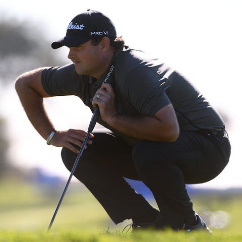 Patrick Reed lines up a putt on the 17th green dur