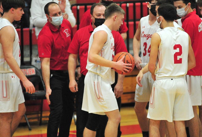 Crestview's Evan Hamilton (23) is congratulated by his teammates and coaches while receiving the game ball after scoring his 1,000th career point during a game against visiting South Central on Friday.