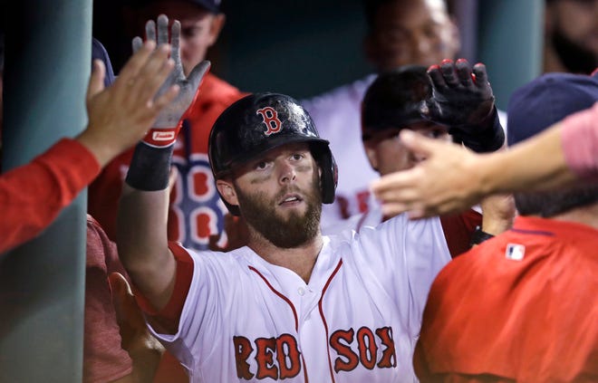 Dustin Pedroia is congratulated after scoring on a triple by Mookie Betts during a game against the Oakland Athletics at Fenway Park in 2017. Pedroia spent the entirety of his 17-year professional career with the Red Sox.