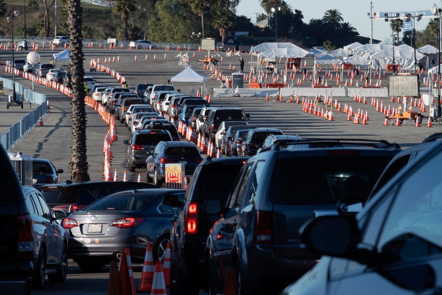 Los Angeles residents wait in line in their cars to receive a covid-19 vaccine at Dodger Stadium, on Jan. 26, 2021, in Los Angeles. California is revamping its vaccine delivery system to give the state more control over who gets the shots following intense criticism of a slow and scattered rollout by counties.