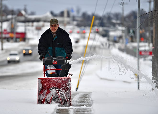 Bryan Kay uses a snow blower to clear the sidewalk outside of his home on Haines Road during winter storm weather in Springettsbury Township, Monday, Feb. 1, 2021. Dawn J. Sagert photo