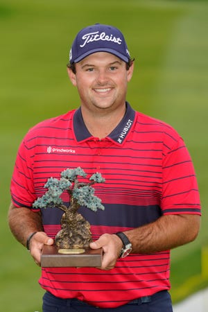 Patrick Reed stands on the South Course while holding his trophy for winning the Farmers Insurance Open golf tournament at Torrey Pines, Sunday, Jan. 31, 2021, in San Diego. [Gregory Bull/The Associated Press]