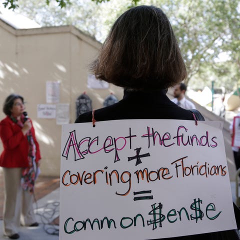 An activist wears a sign in support of Florida law