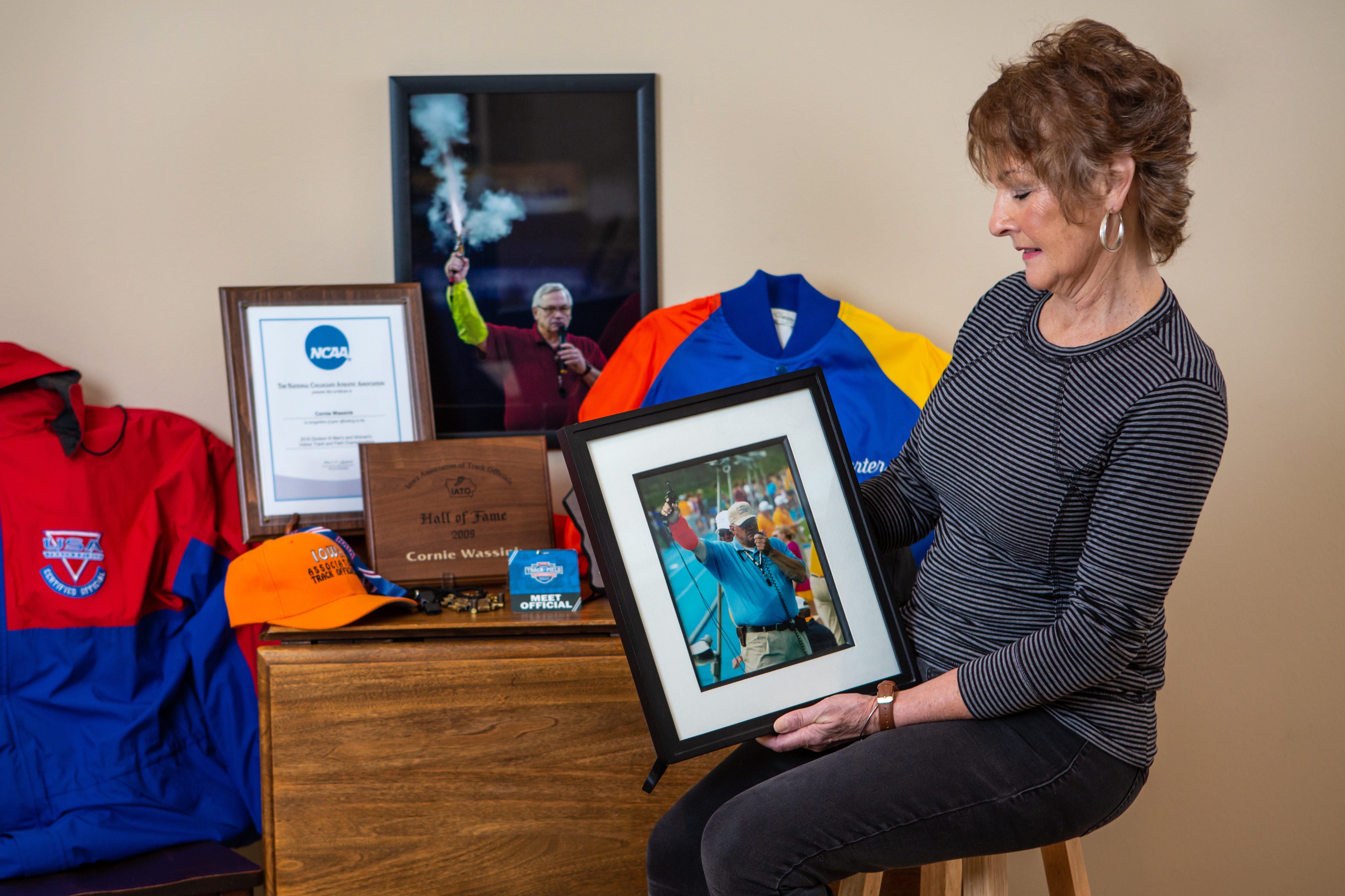Deb Wassink holds up a picture of her late husband Cornie Wassink who was a beloved track and field official throughout the state.