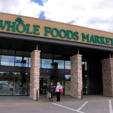 People stand outside a Whole Foods Market in Upper