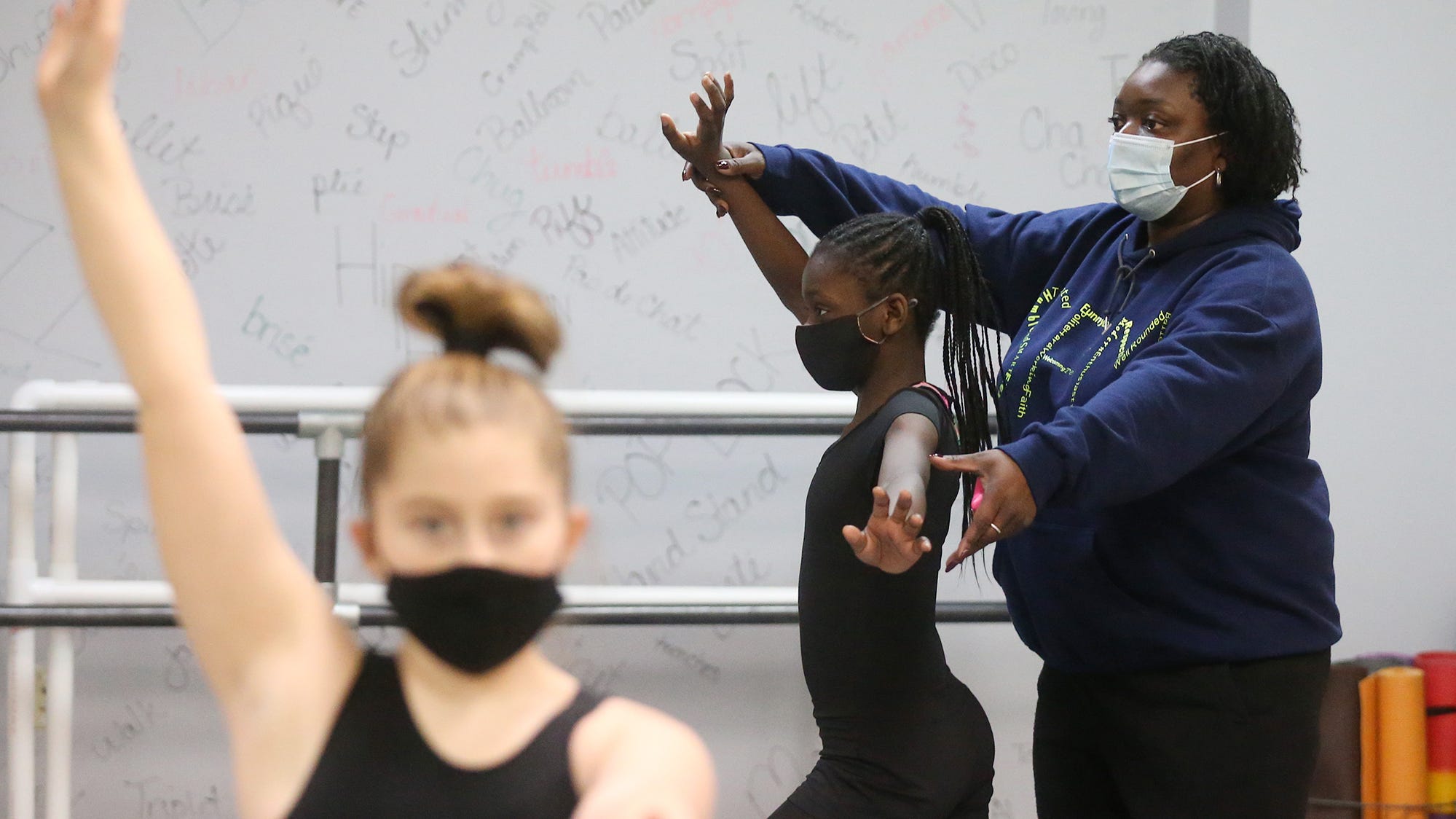 Sheena Mason of Sheena's Platinum Dance Movements works with Chyan Rogers, 11, on placement during a class at her studio in Akron.
