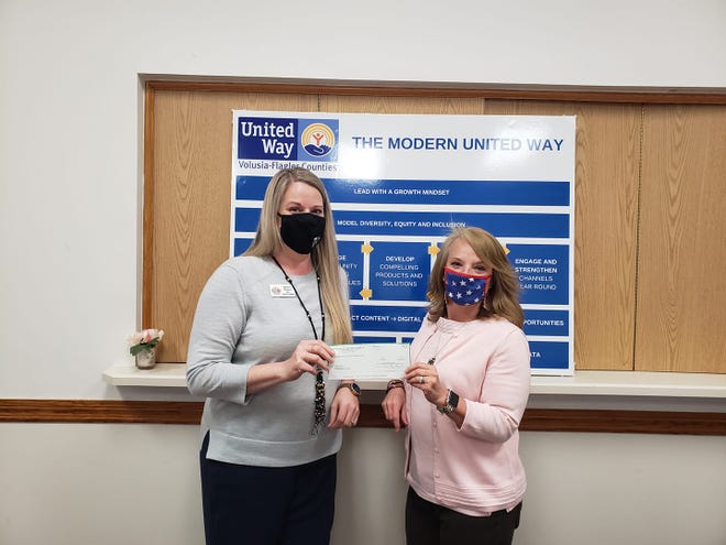 Sheila Pillath, director of resource development for United Way, hands the grant check to Shimene Shepard, student services and mentor coordinator for Take Stock in Children.