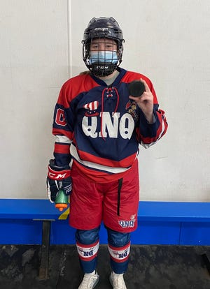 Sophomore Maggie Lynch poses with the game puck after recording her 100th career point for the Quincy/North Quincy High girls hockey co-op program. Lynch had six goals and two assists in a 14-8 win over Scituate on Thursday, Feb. 4, 2021 at Quincy Youth Arena.