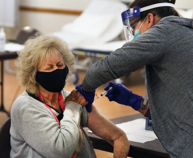 June Clark grimaces as she receives her vaccine.