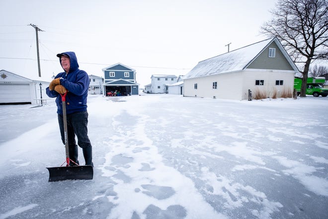 East China resident Bill Miller stands in his frozen driveway Friday, Feb. 5, 2021, on Pointe Drive.