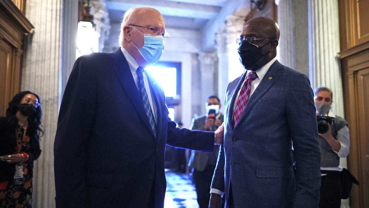Senate President Pro Tempore Patrick Leahy, D-Vt., speaks with Sen. Raphael Warnock, D-Ga., outside the Senate chamber on Jan. 28. Leahy will preside over the second impeachment trial of Donald Trump.