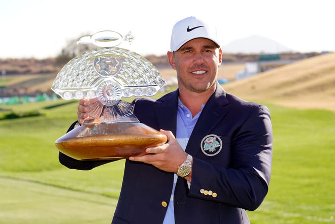Brooks Koepka poses with the trophy after winning a PGA golf tournament on Sunday, Feb. 7, 2021, in Scottsdale, Ariz. (AP Photo/Rick Scuteri)