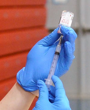 Drawing a COVID-19 vaccine draw from a vial.