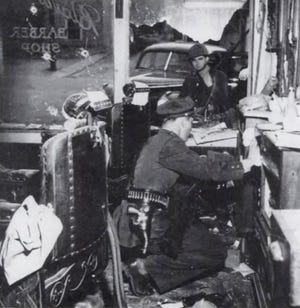 Ein Mitglied der Tennessee Highway Patrol fegt durch Saul Blairs Friseurladen im Bottom, als ein Staatswächter am 26. Februar 1946 durch ein Fenster schaut.