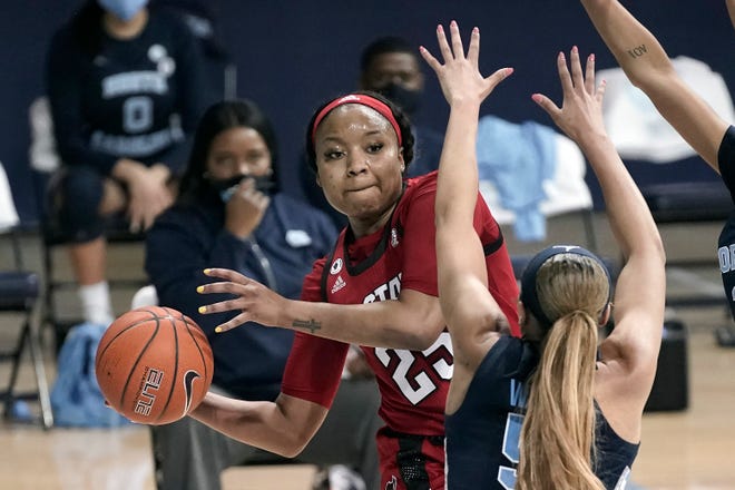 North Carolina State forward Kayla Jones (25) passes around North Carolina guard Stephanie Watts (5) during the first half of an NCAA college basketball game in Chapel Hill, N.C., Sunday, Feb. 7, 2021. (AP Photo/Gerry Broome)