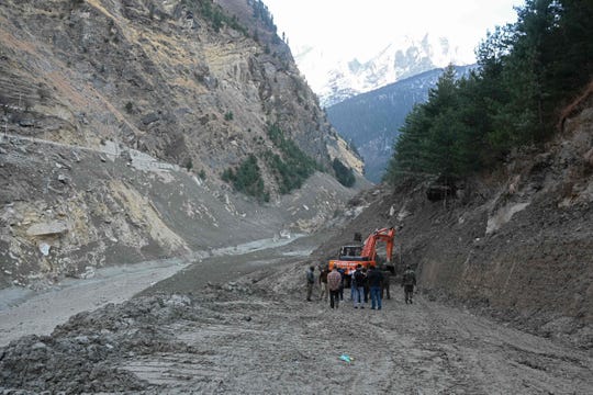 Uma sonda limpa a estrada para a destruída Ponte Raini no distrito de Shamuli em Uttarakhand, Índia, em 8 de fevereiro de 2021, depois de ter sido arrastada por enchentes causadas por uma explosão de geleira no dia anterior.
